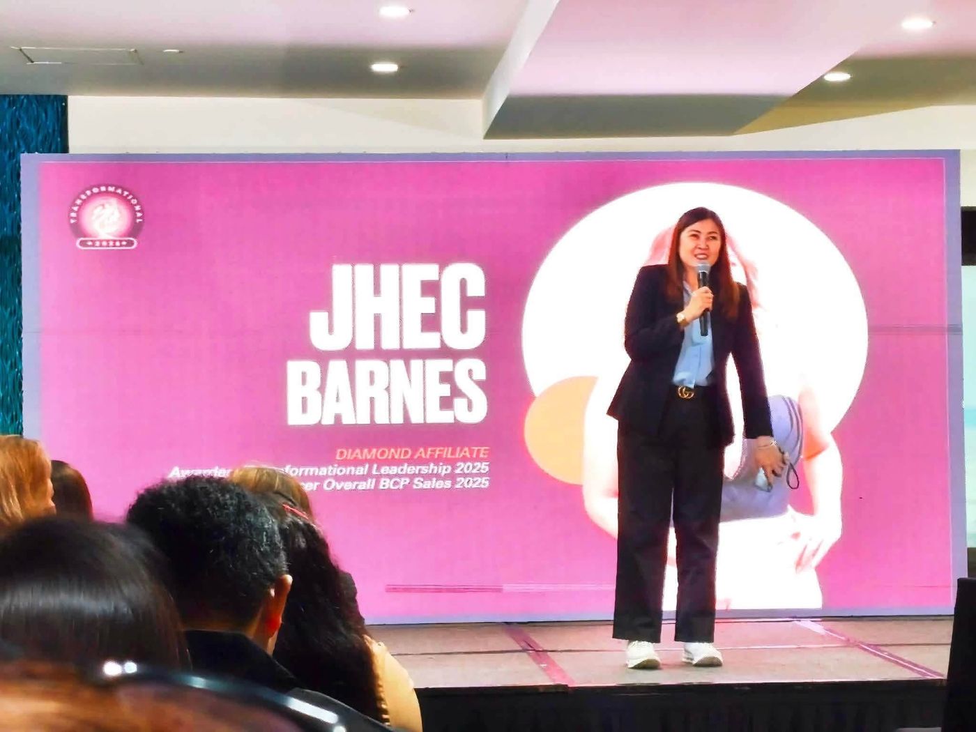Jhec Barnes on stage at a WCA Travel recognition event